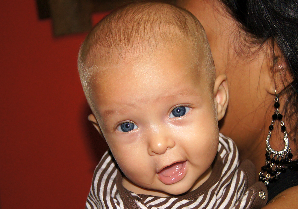 Bebé con ojos azules abriendo su boca