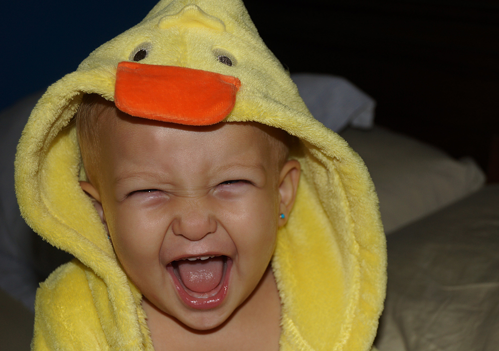 Bebé feliz vestida con una bata de pato